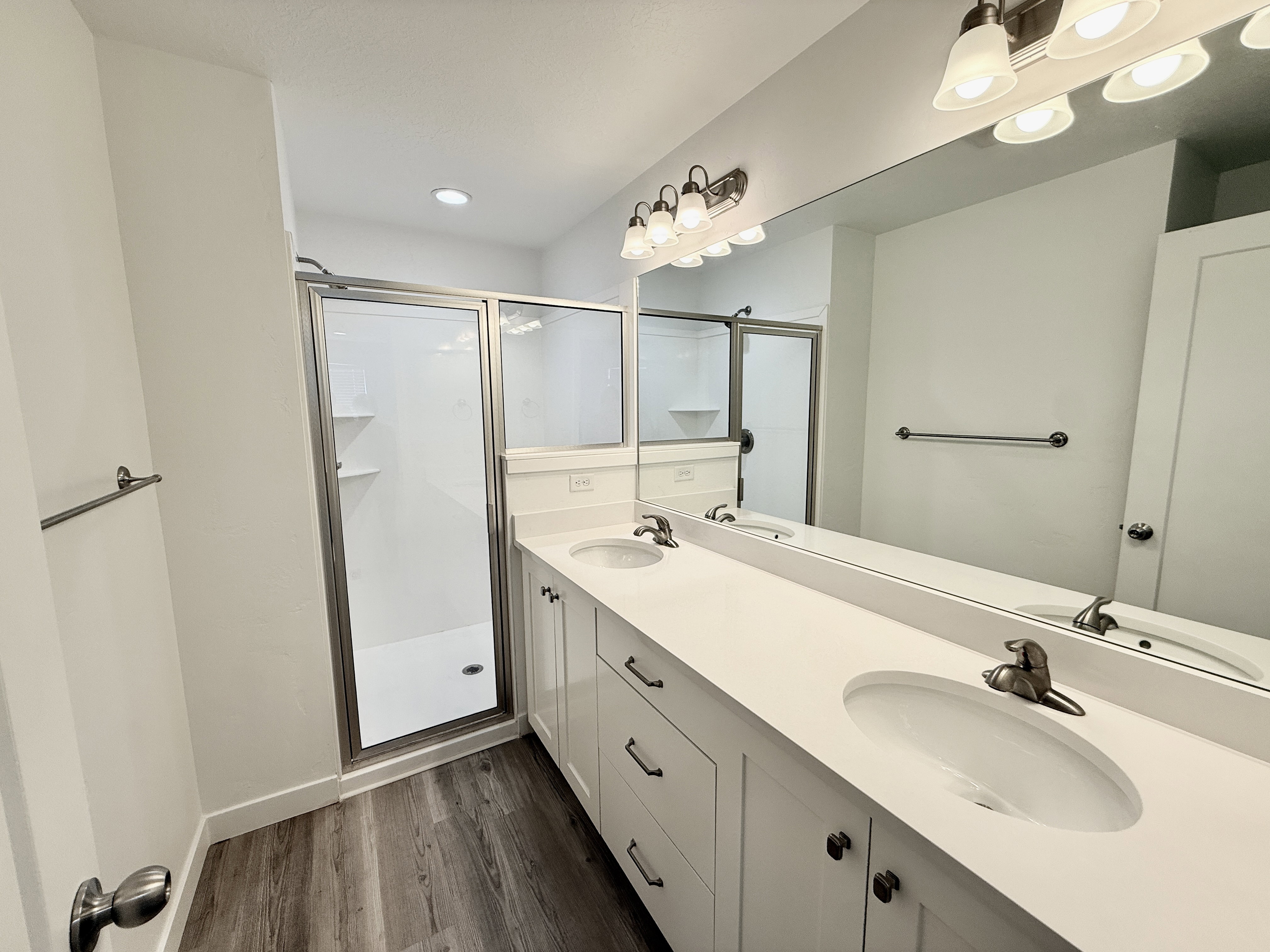Bathroom featuring a dual vanity with white cabinetry, white countertops, and undermount sinks