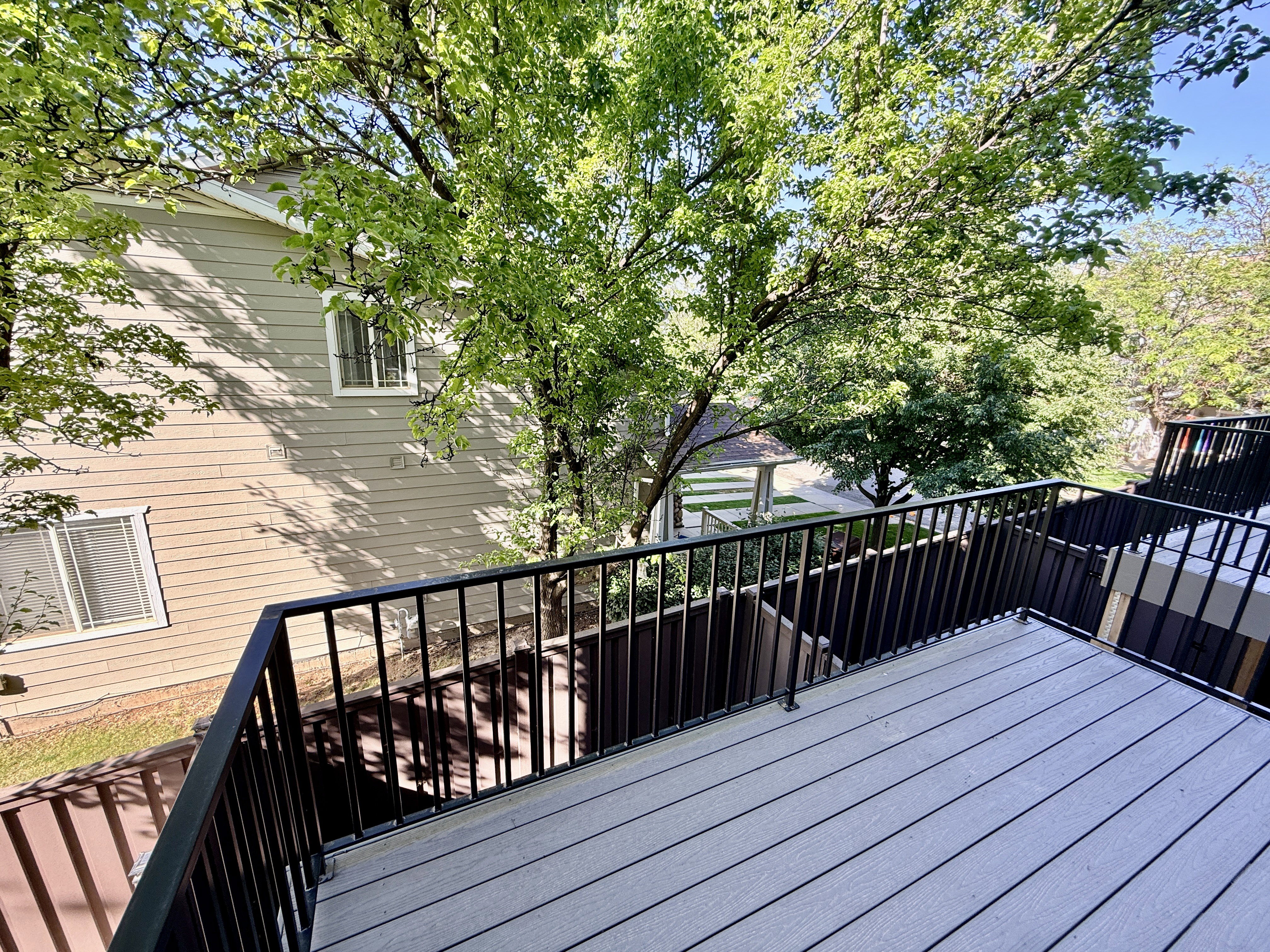 Upper-level balcony featuring composite decking and black metal railings