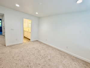 Carpeted room with recessed lighting and white baseboards