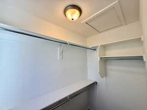 Walk-in closet featuring white painted walls, multiple shelving units, and clothing rods for organization