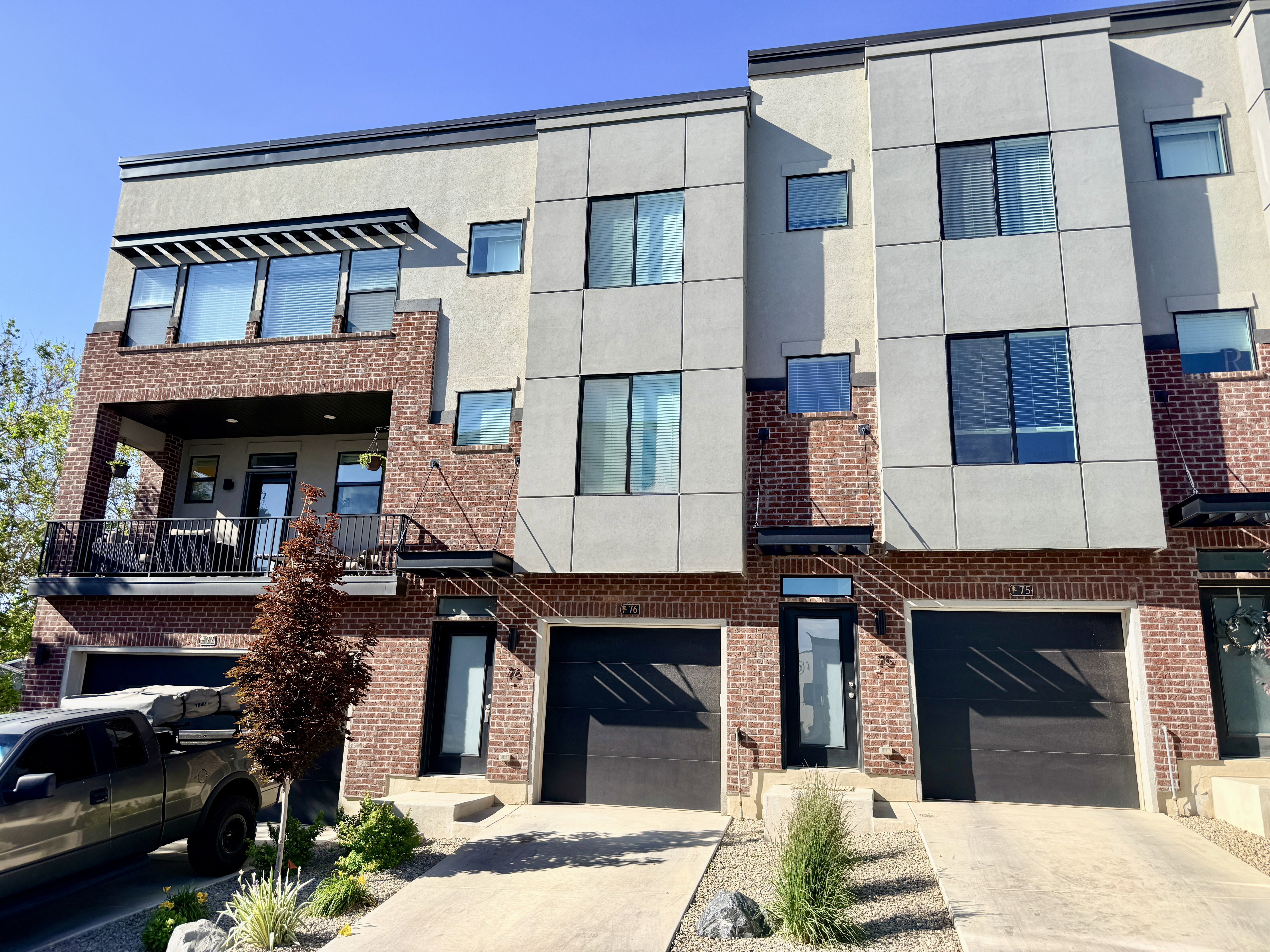Modern townhome exterior featuring brick and panel siding
