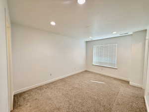 Carpeted room featuring recessed lighting, a window with horizontal blinds, and clean white walls