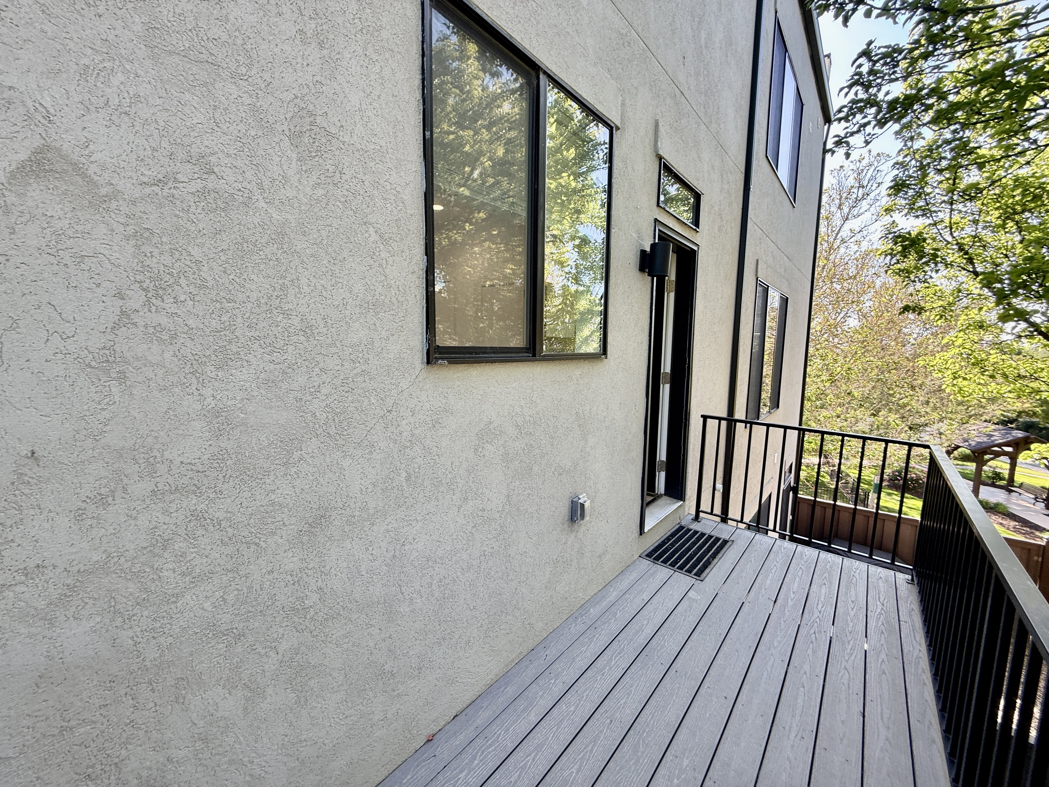 Exterior balcony featuring composite decking and black metal railings