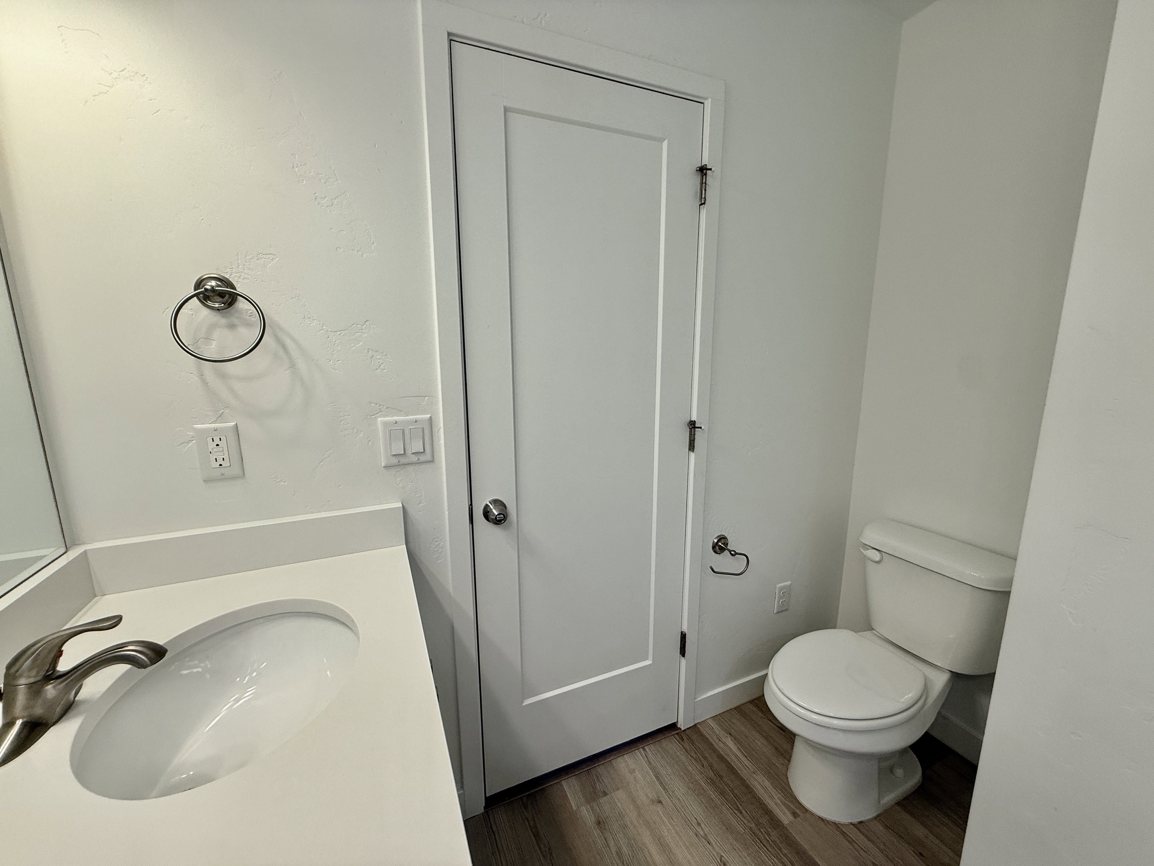Contemporary bathroom featuring a white vanity with an integrated sink and brushed nickel faucet