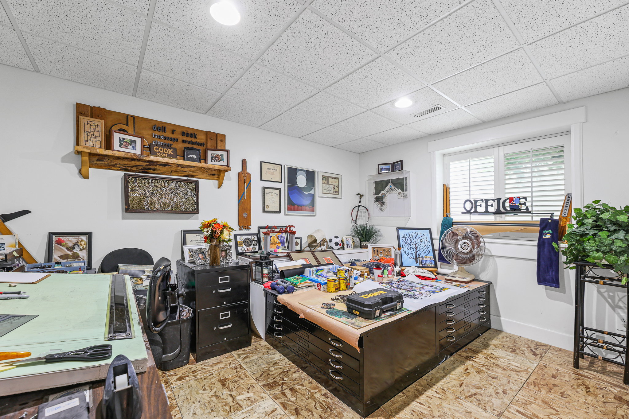 Finished room featuring white walls, a grid panel ceiling, and a large window with white blinds