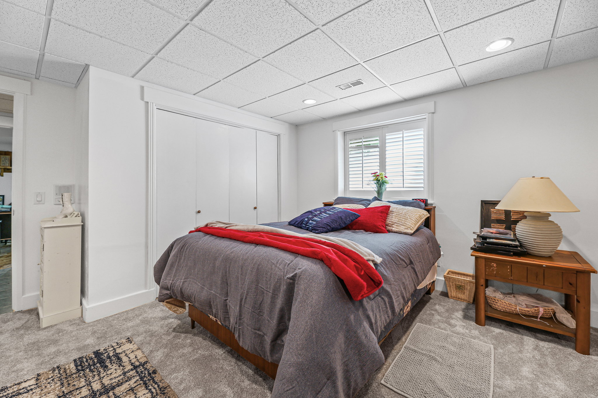 Carpeted room with a drop ceiling featuring recessed lighting