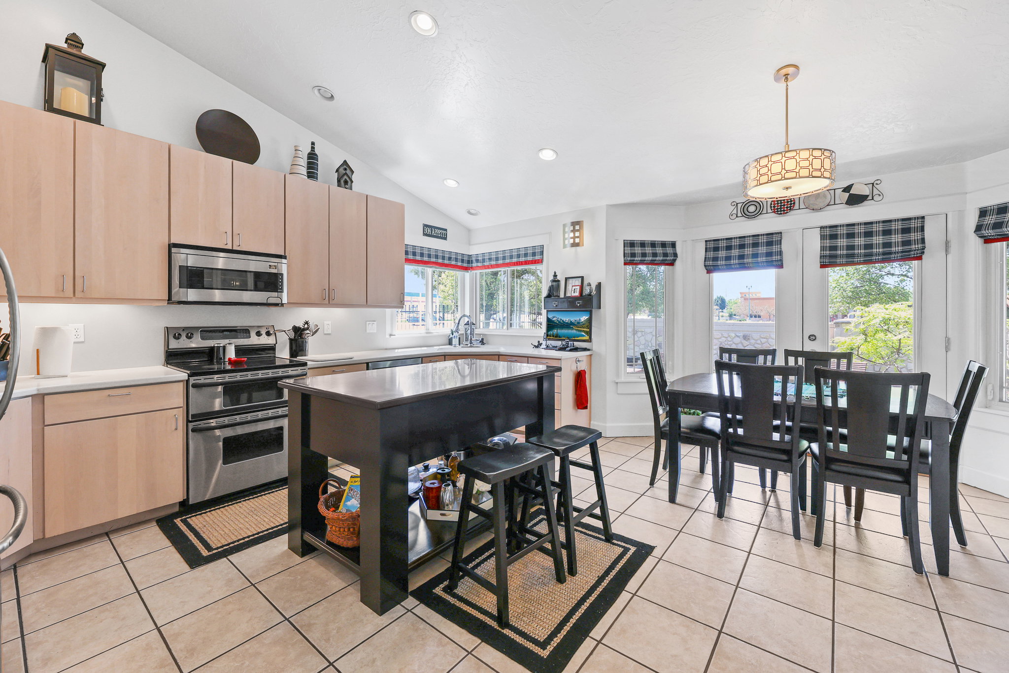 Spacious kitchen featuring light-toned cabinetry, stainless steel appliances, and a central island with an integrated breakfast bar