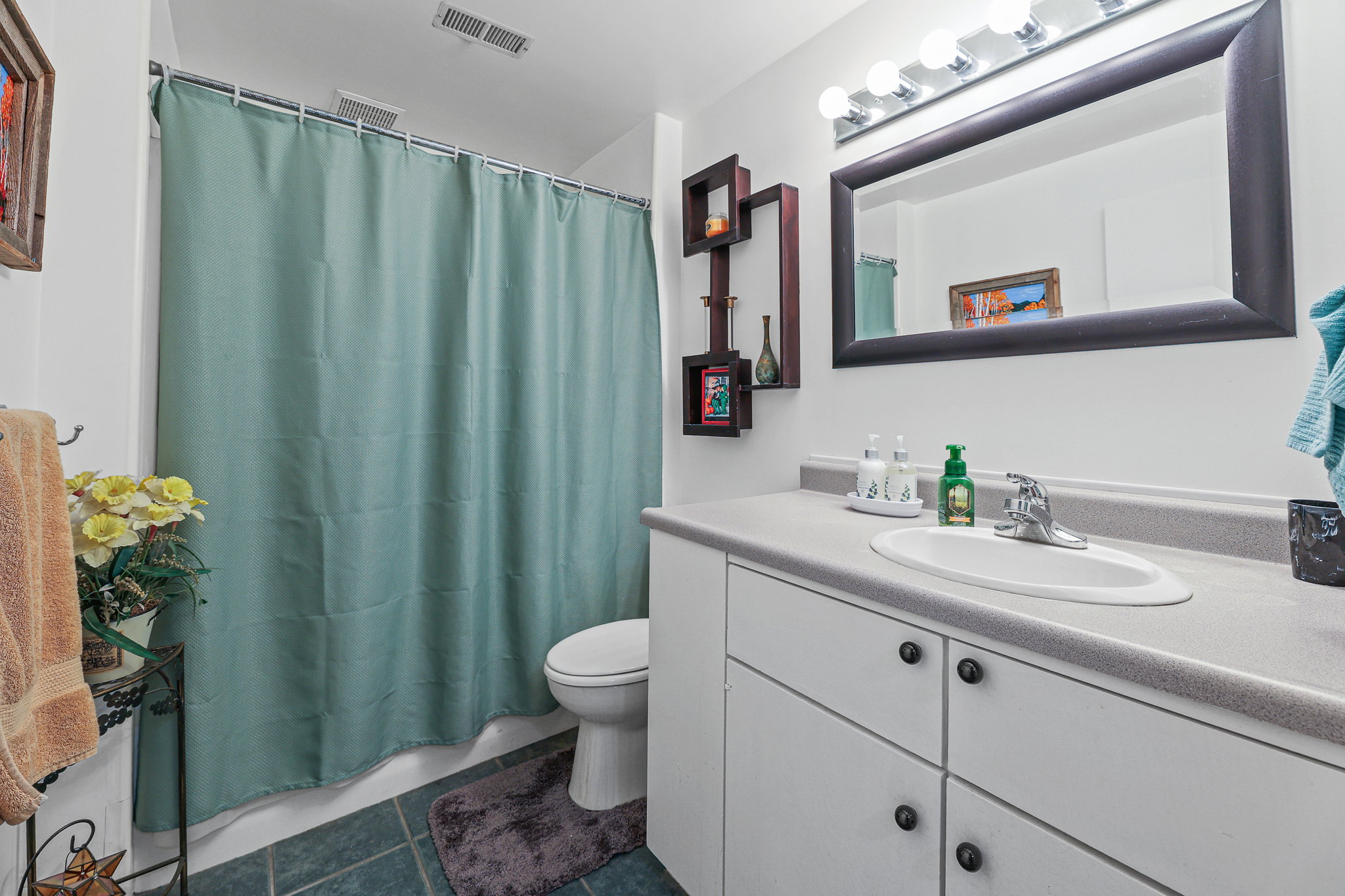 Bathroom featuring a full vanity with an integrated sink, polished chrome faucet, and ample under-sink storage