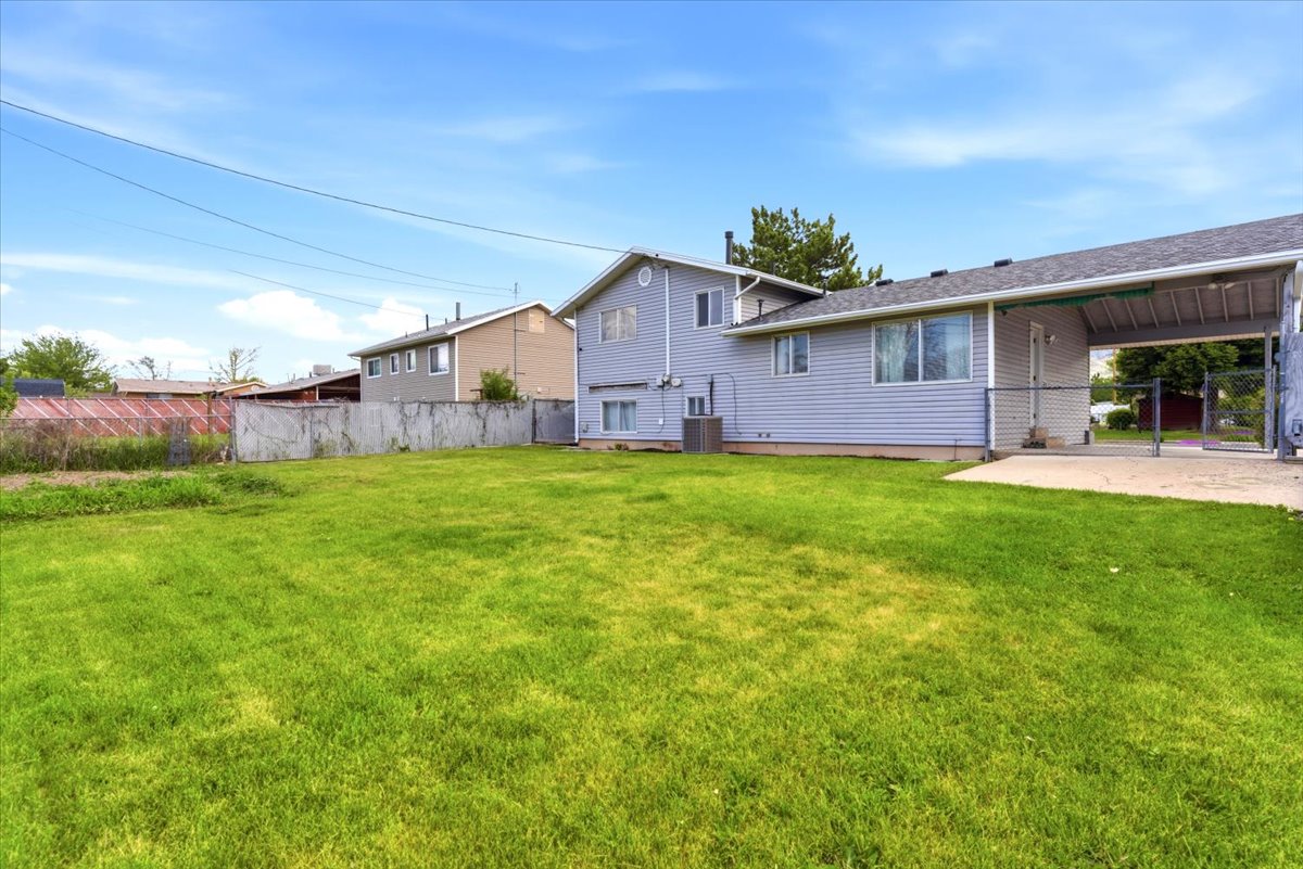 Expansive grassy yard with a concrete patio directly off the home
