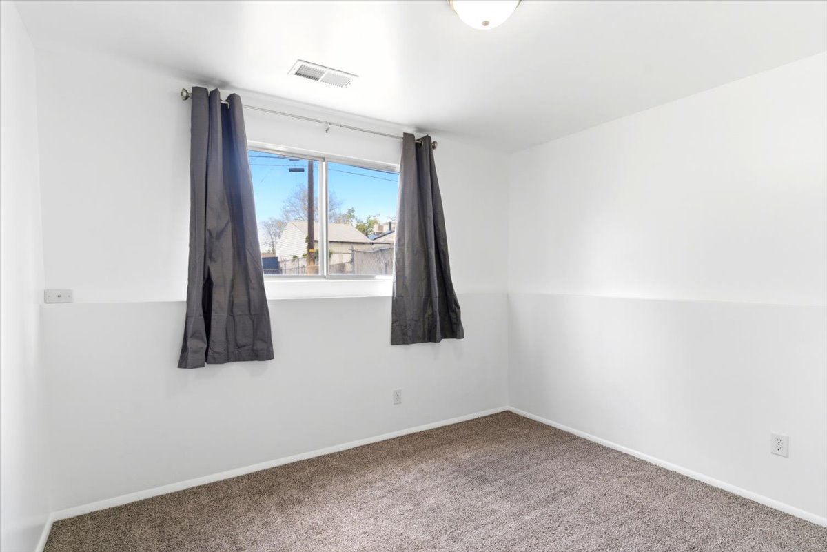 Bright room with white painted walls, a window, and gray carpet flooring