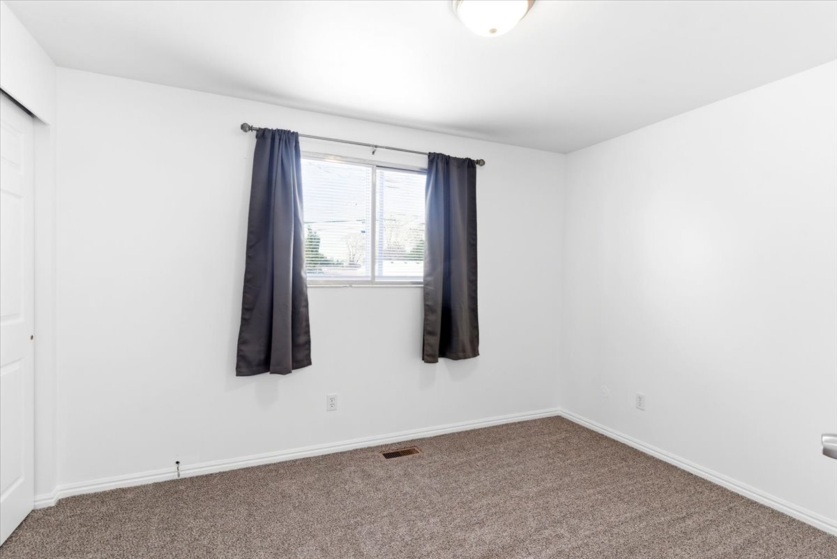 Room featuring neutral paint, carpet flooring, a window with blinds, and white trim