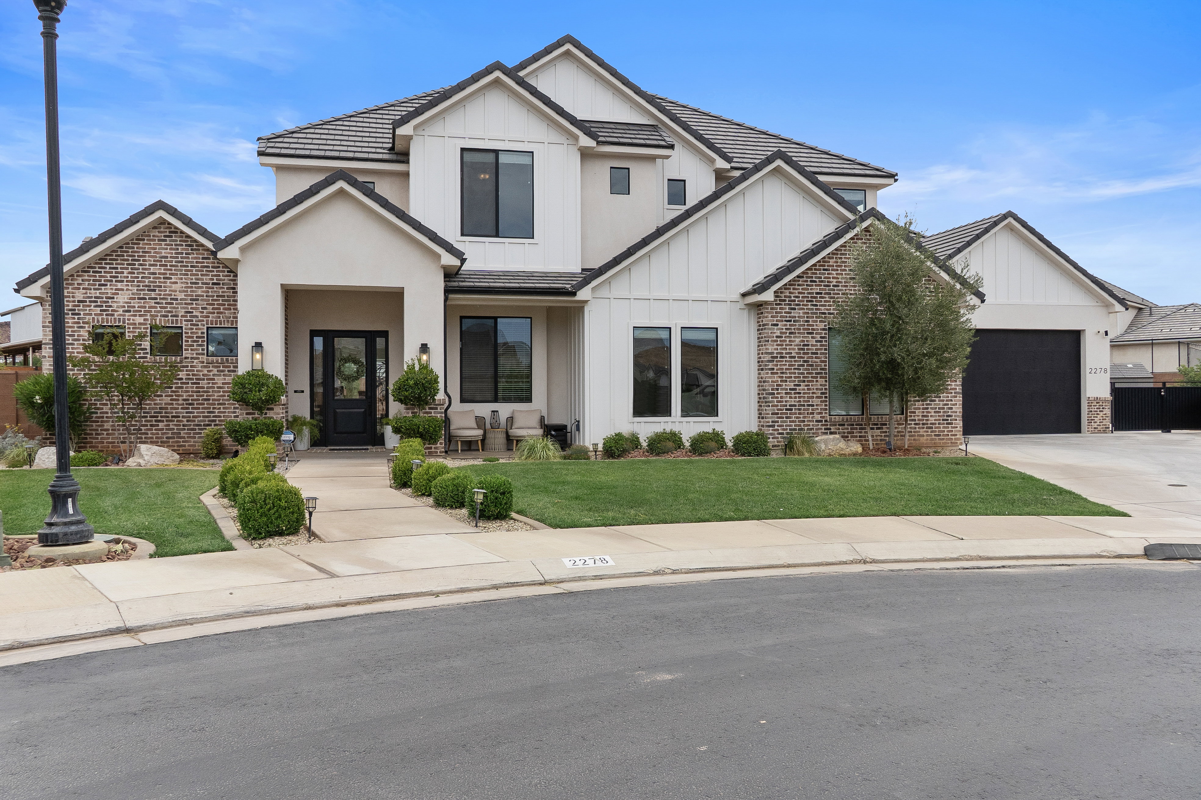 Contemporary residence featuring a stucco and brick exterior with board and batten accents.