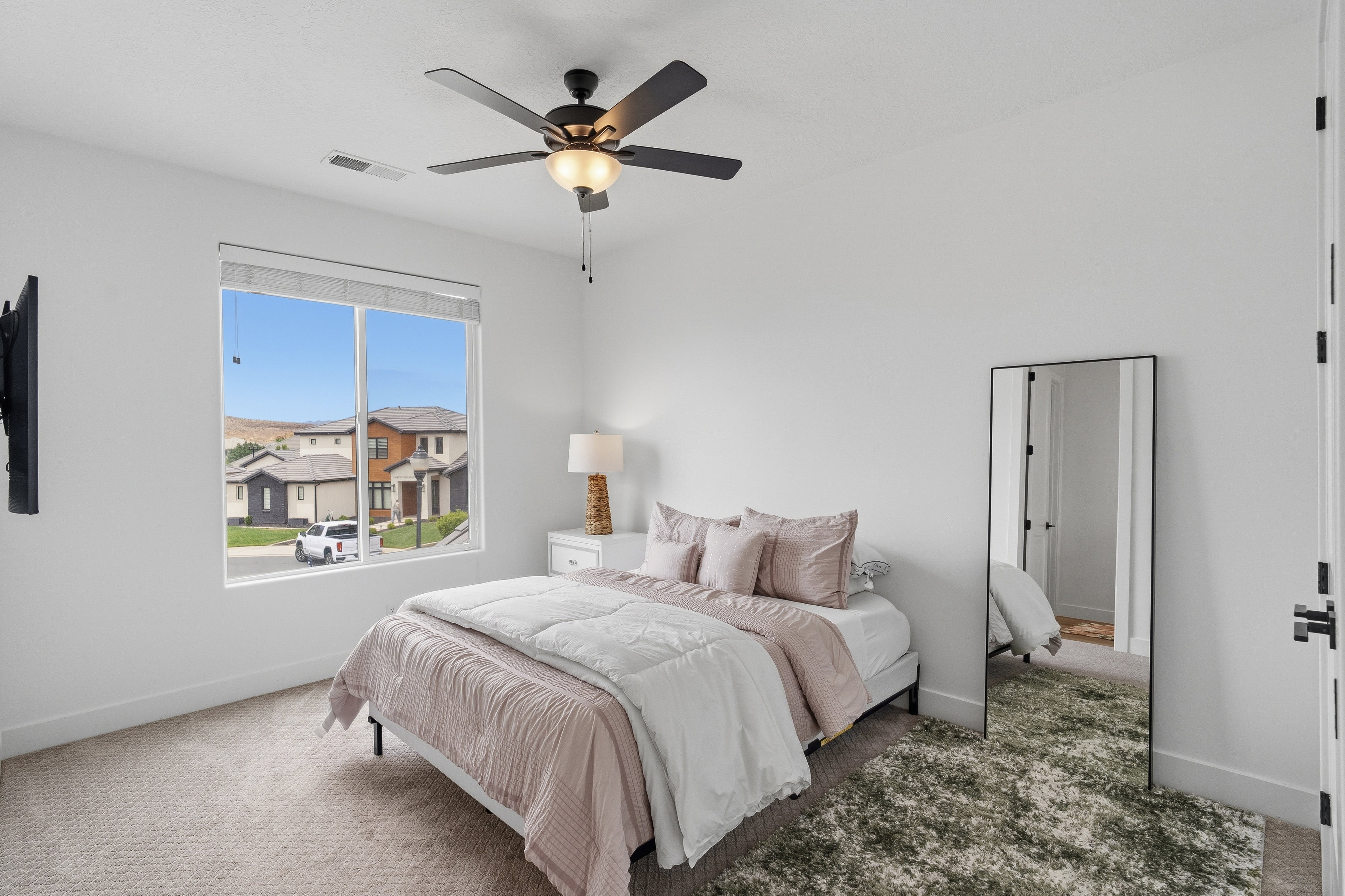 Bright bedroom featuring a large window, a ceiling fan with integrated lighting, recessed lighting, and soft carpet flooring
