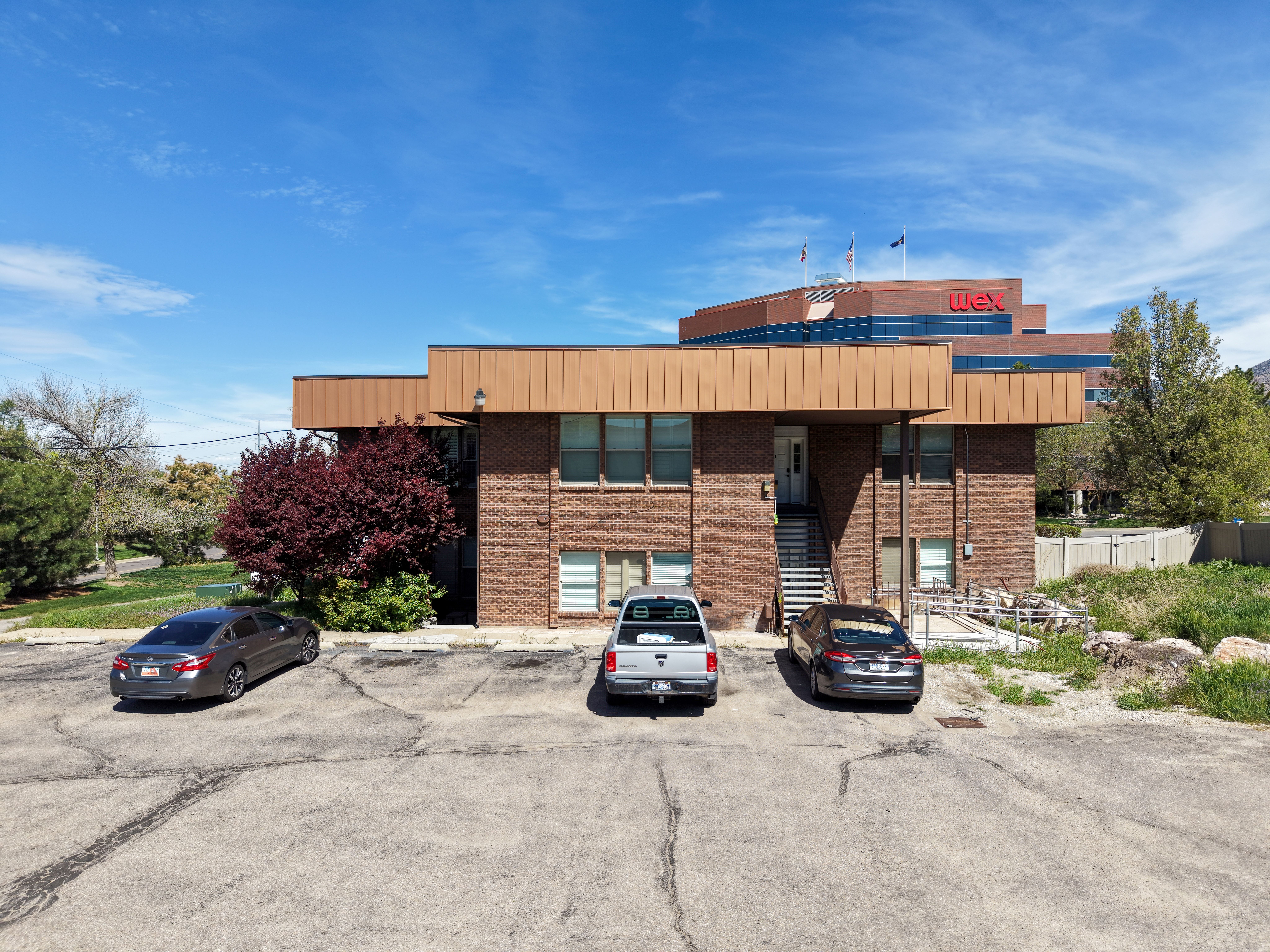 Two-story brick building with a brown panel facade and multiple windows