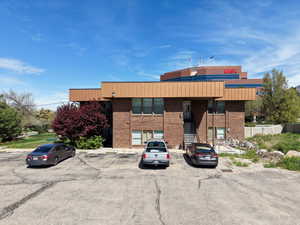 Two-story brick building with a brown panel facade and multiple windows