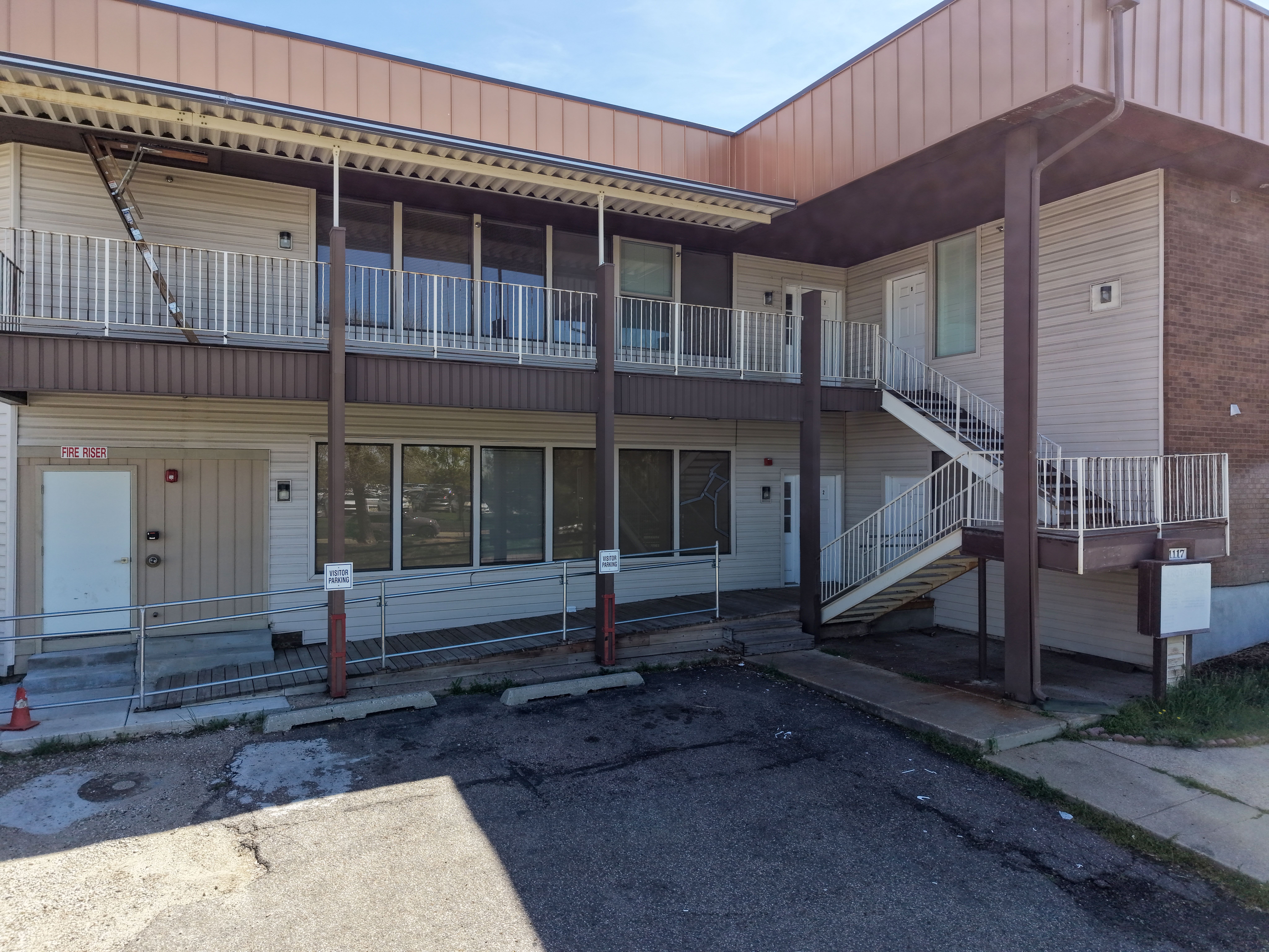 Multi-level exterior featuring light-toned siding and dark trim