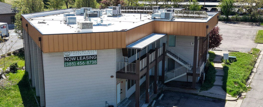 Multi-level building with beige siding and brown trim