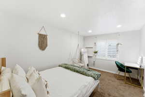 Bedroom featuring recessed lighting, a window with plantation shutters, neutral wall tones, and carpet flooring