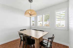 Bright interior space featuring wood-finish flooring, white baseboards, and clean white walls