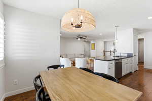 Open-concept dining area featuring a natural wood dining table and a woven pendant light fixture
