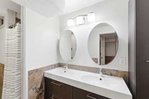 Dual oval mirrors above a contemporary double vanity with integrated sinks