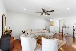 Open-concept living space featuring wood-finish flooring, recessed lighting, and a ceiling fan