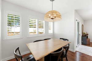 Dining space featuring wood-finish flooring and a woven pendant light fixture
