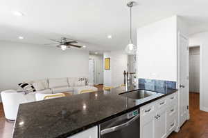 Kitchen island featuring a stainless steel sink and dark countertop