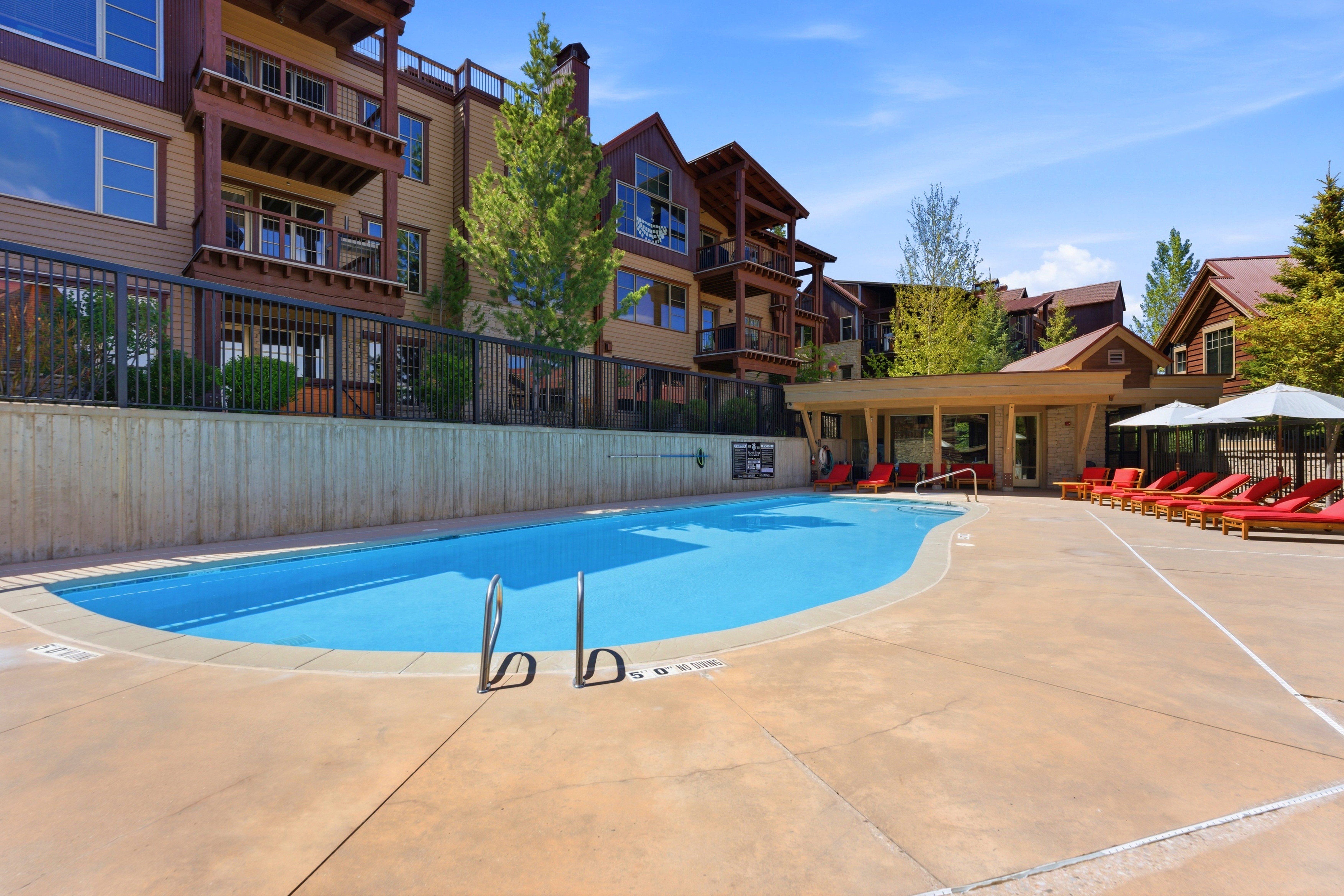 Community swimming pool with an expansive concrete deck and a covered cabana area