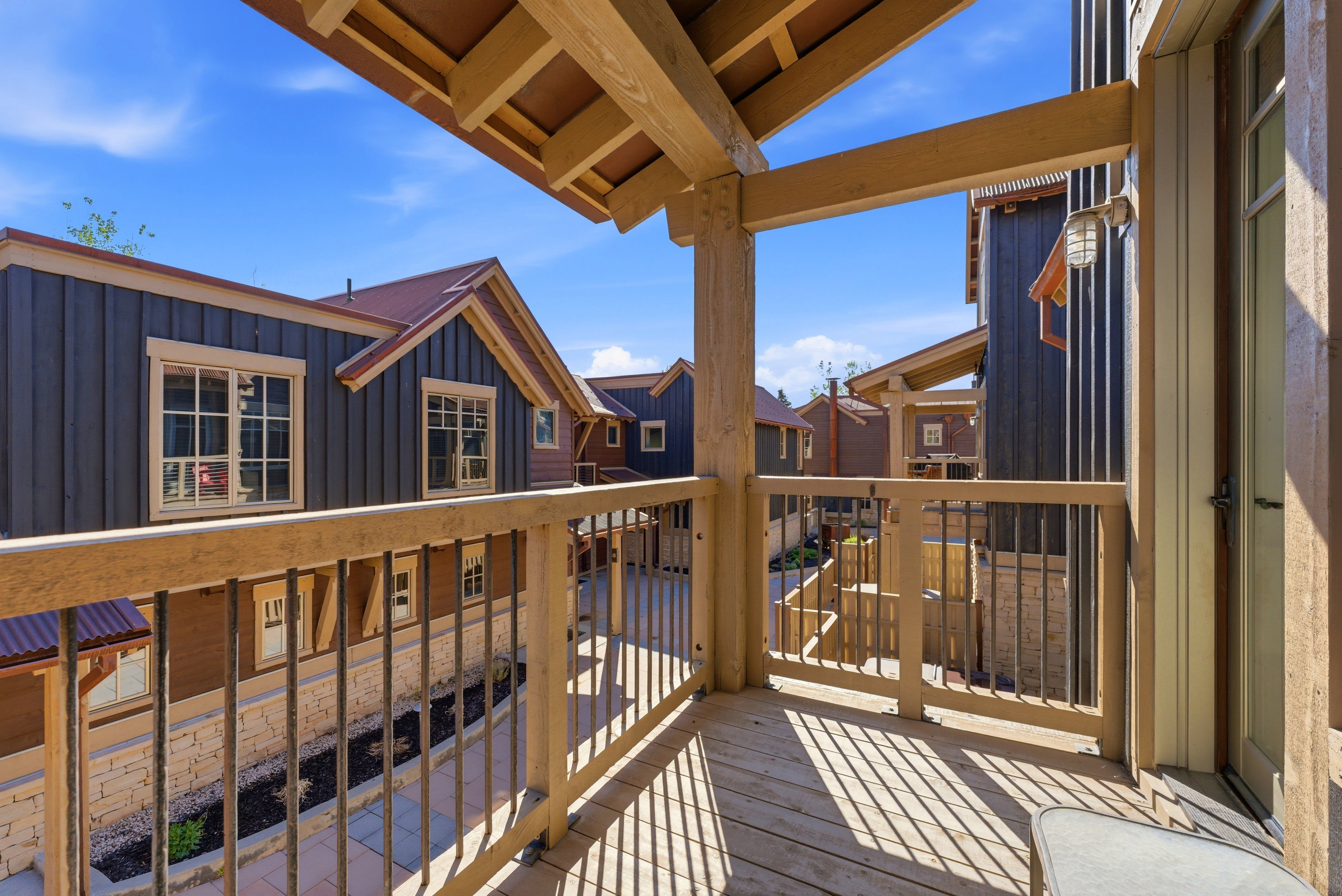 Private balcony with wood-finish decking and open-rafter ceiling