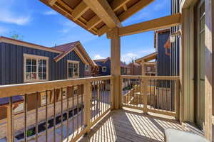 Private balcony with wood-finish decking and open-rafter ceiling