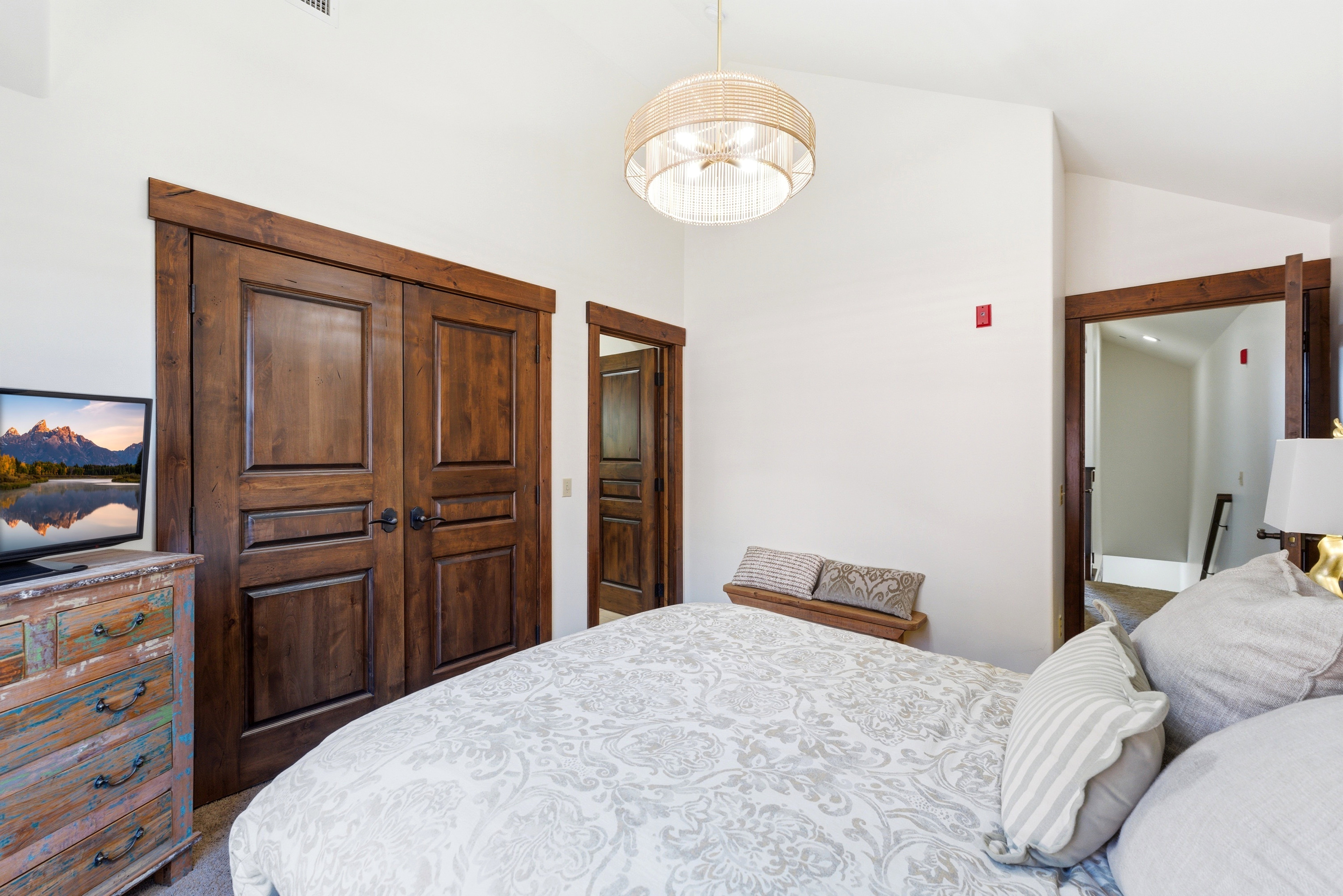 Room featuring vaulted ceilings and a statement woven pendant light fixture