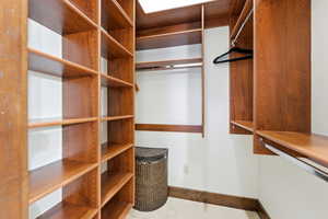 Custom closet system featuring rich wood-finish shelving, multiple hanging rods, and integrated storage solutions