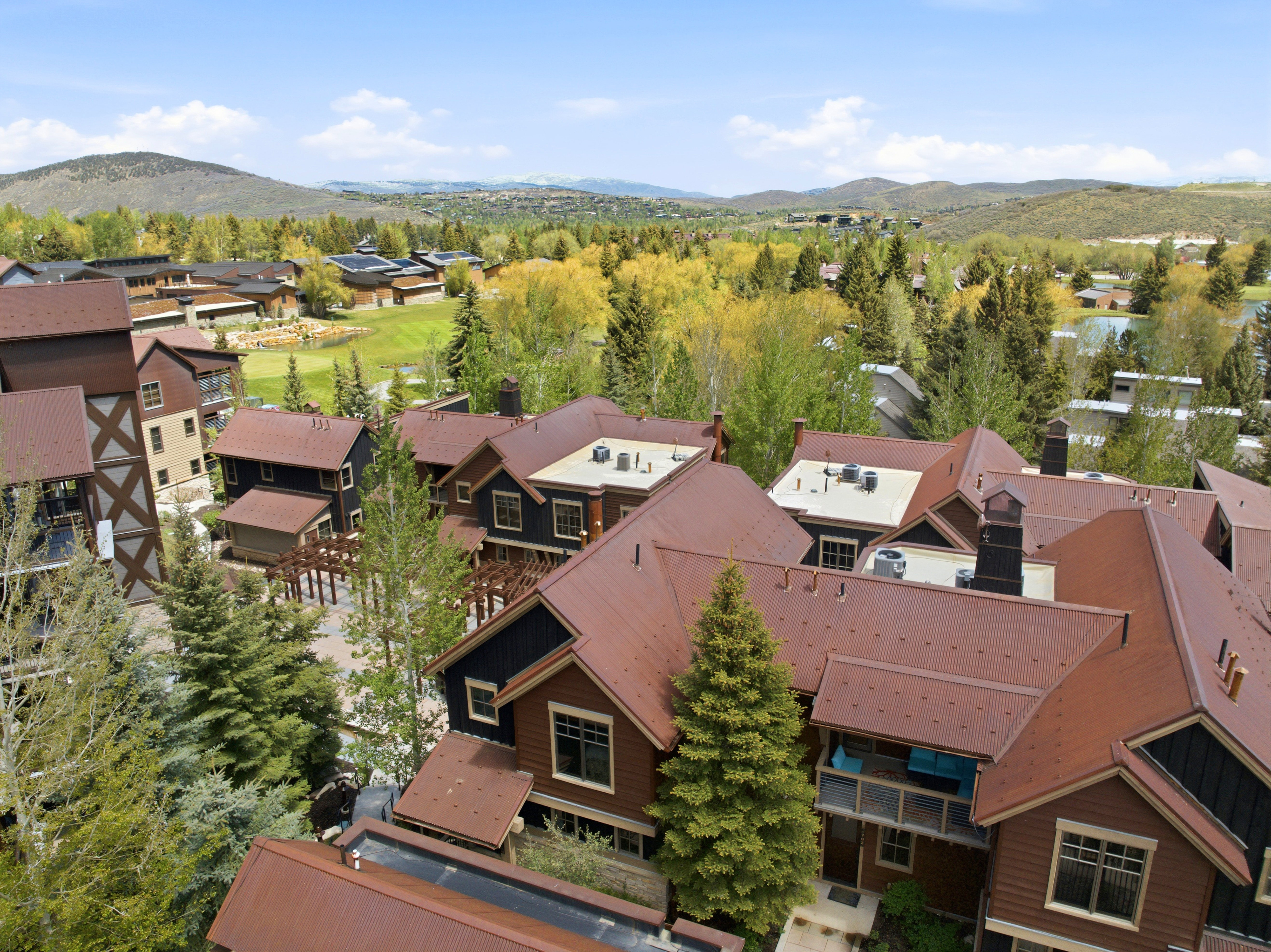 Contemporary multi-level residences featuring brown metal roofs and dark wood siding