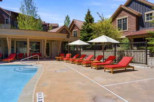 Outdoor swimming pool featuring integrated steps and a metal handrail
