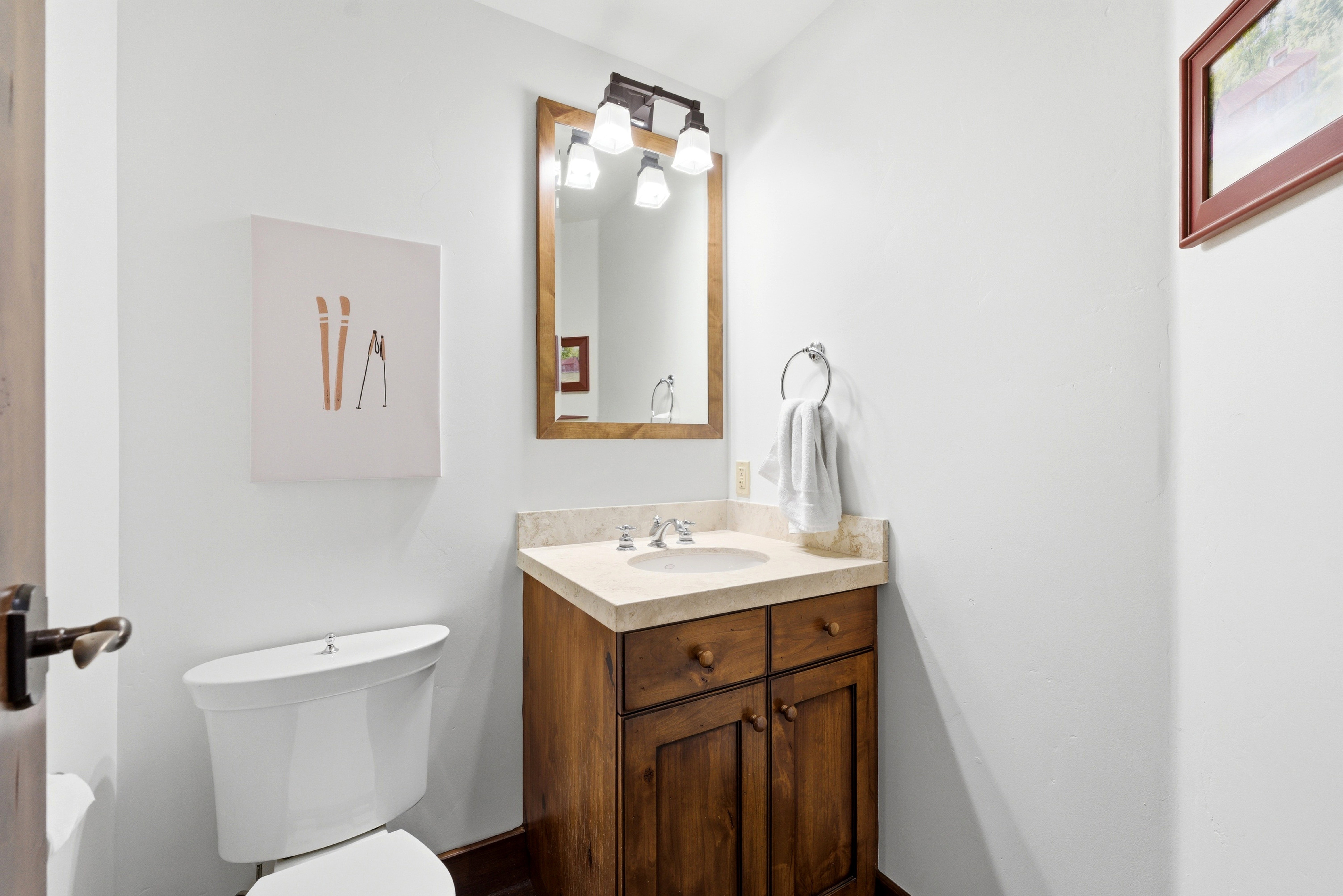 Vanity with wood cabinetry, light-toned countertop, and undermount sink