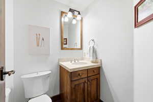 Vanity with wood cabinetry, light-toned countertop, and undermount sink