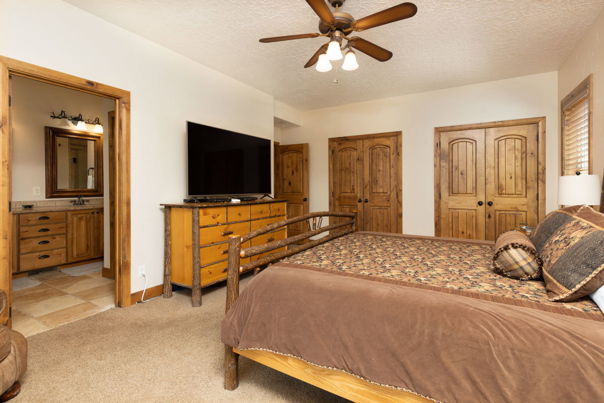 Spacious room featuring carpeting, a ceiling fan, and solid wood double doors
