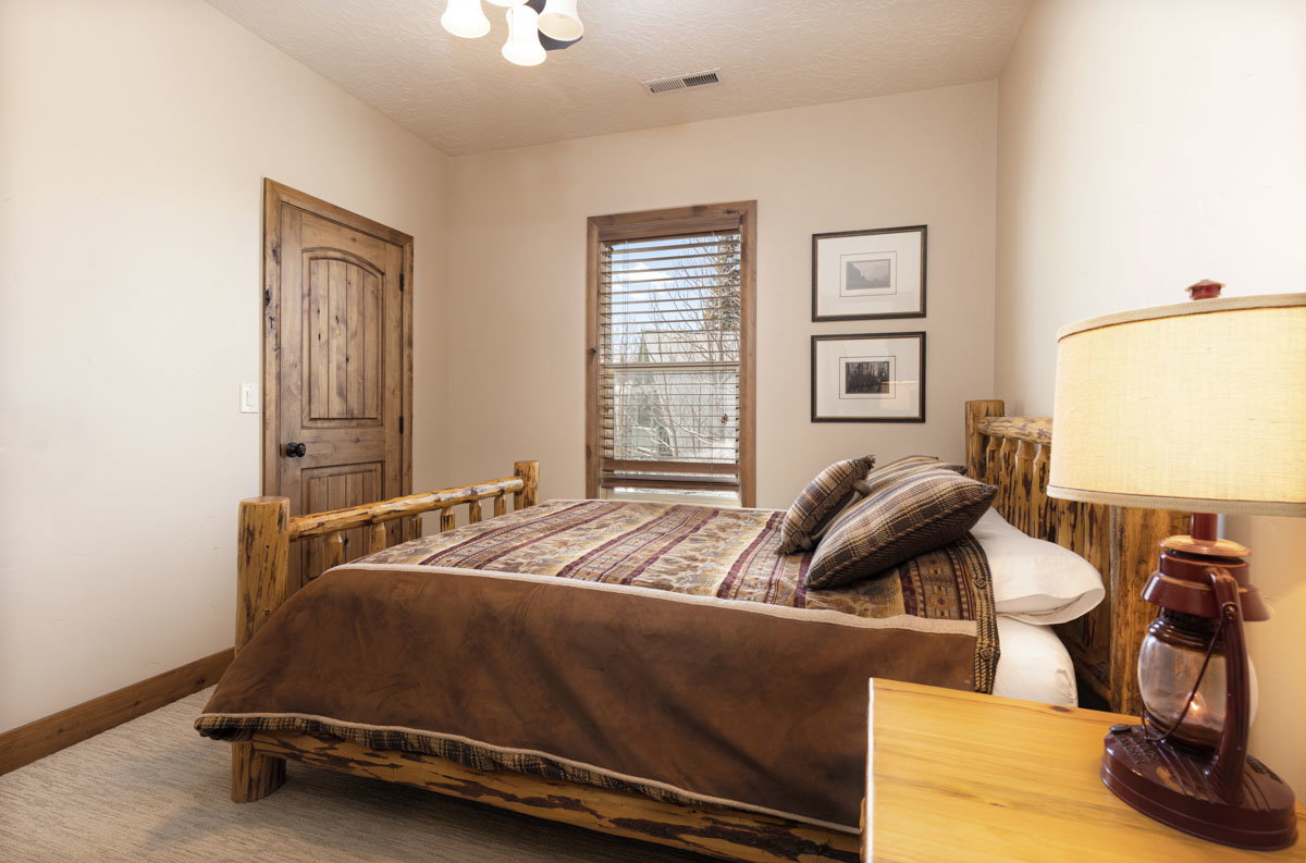 Carpeted room featuring a rustic wood-finish door, matching trim, and a window with wood-finish blinds