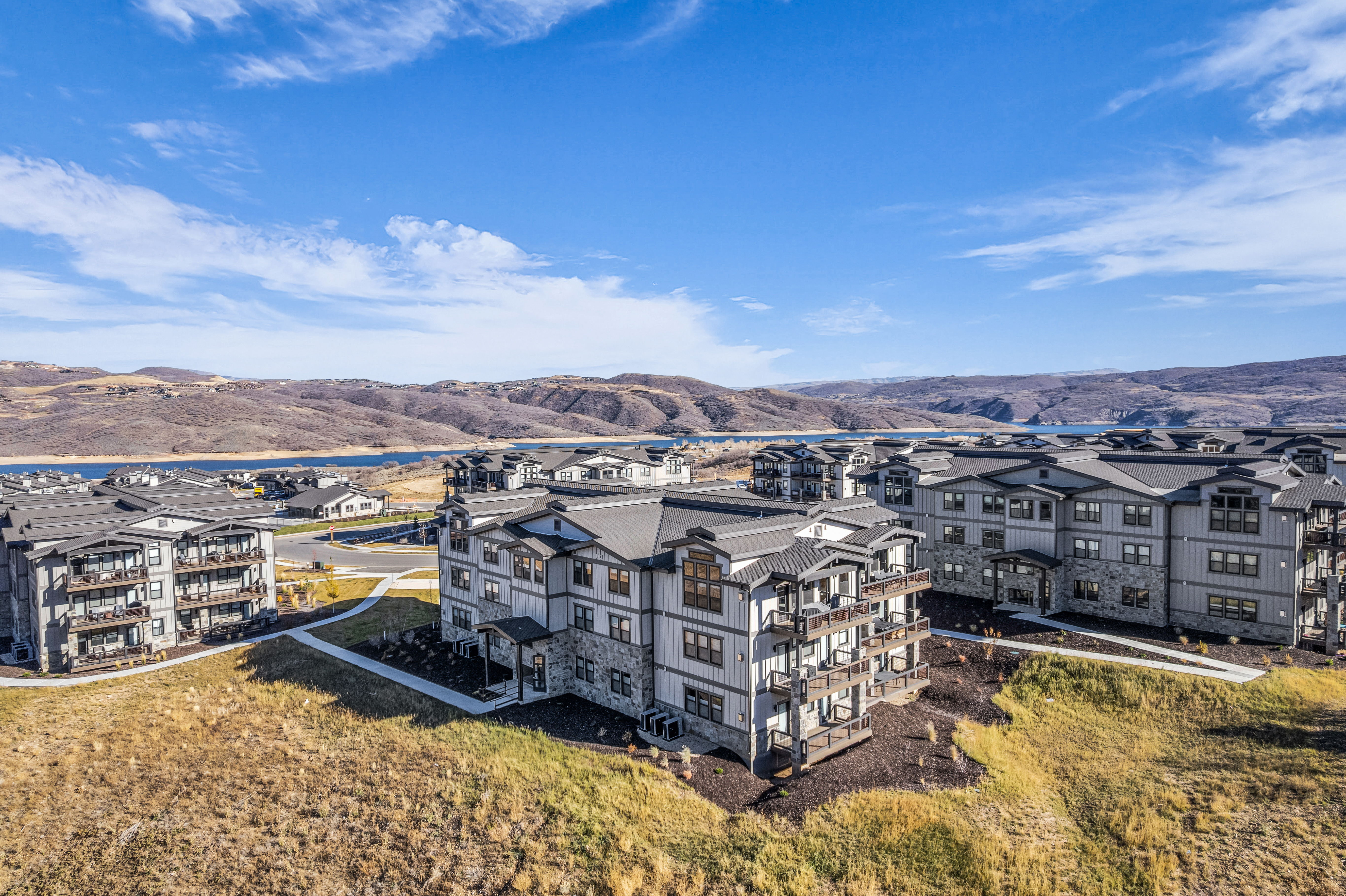 Modern residential buildings with multi-level balconies and dark-pitched roofs