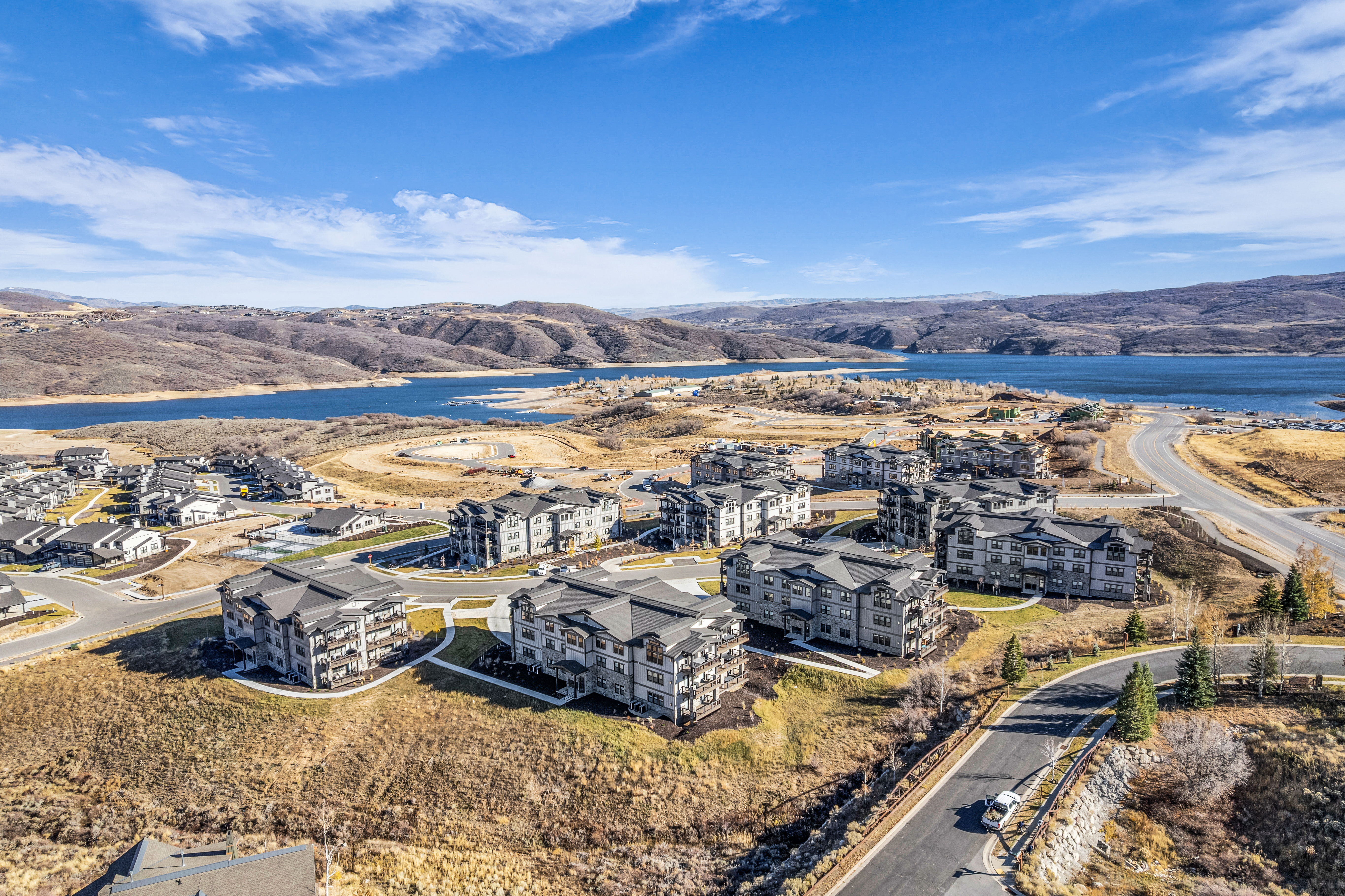 Expansive hillside community featuring multi-story residential buildings with dark roofs and light-toned siding