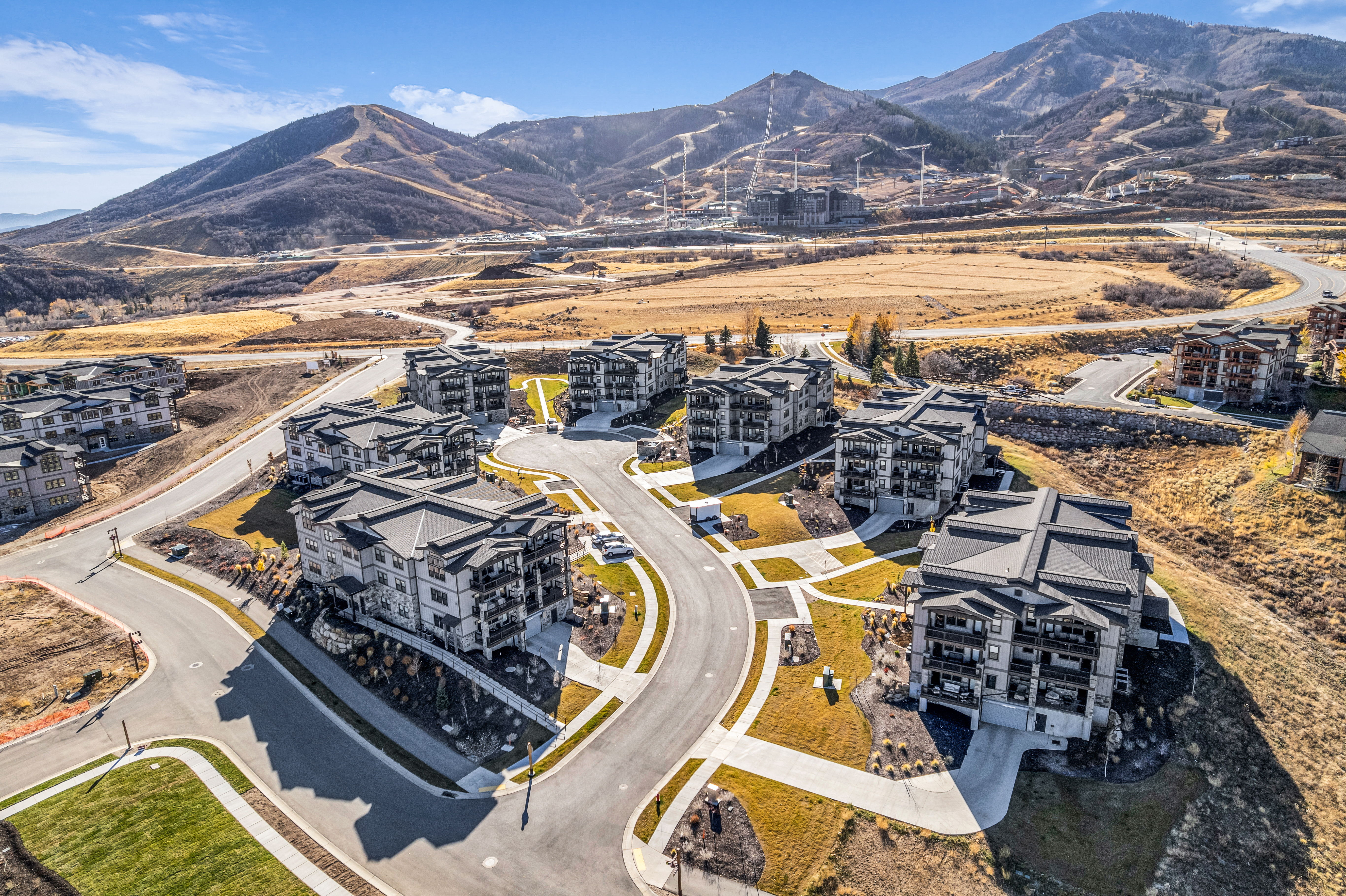 Modern multi-story buildings featuring balconies and dark-pitched roofs