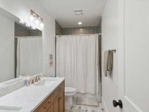 Bathroom featuring a double vanity with stone countertops, wood cabinetry, and brushed nickel fixtures