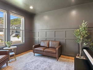 Room featuring board and batten wall trim, wood-finish flooring, recessed lighting, and large windows