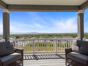 Covered deck featuring a white railing and composite decking