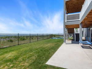 Expansive sloped lawn with black metal fencing