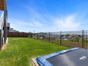 Expansive grass lawn with a multi-level deck and concrete patio