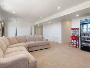 Spacious recreation room featuring recessed lighting, light-toned carpeting, and white painted walls