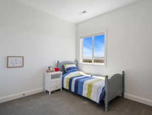 Bright room featuring a large window, neutral wall paint, gray carpet flooring, and white trim