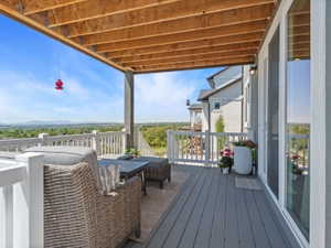 Covered outdoor deck featuring composite decking, white railing, and a tongue-and-groove wood ceiling